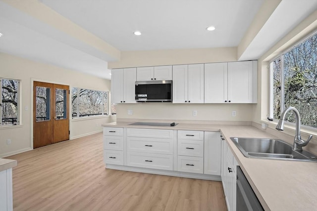 kitchen with stainless steel appliances, a sink, white cabinets, light wood-style flooring, and recessed lighting