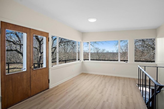 unfurnished sunroom with wood finished floors and plenty of natural light