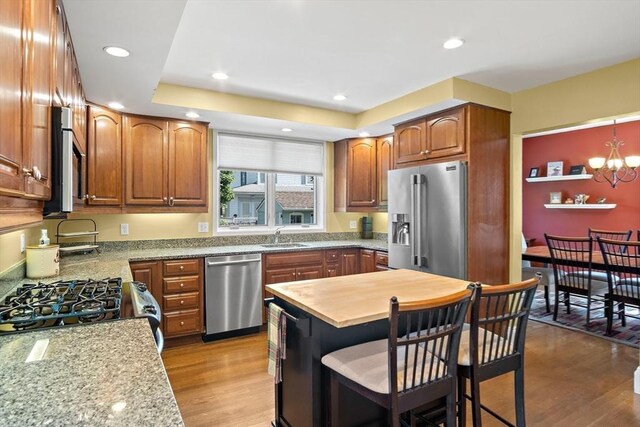 35 Harvard St, Winchester, MA 01890 - kitchen with appliances with stainless steel finishes, a sink, a chandelier, wood finished floors, and a kitchen breakfast bar