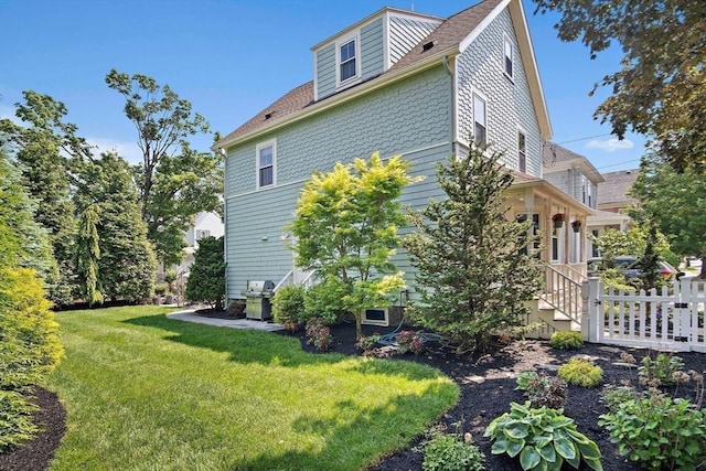 35 Harvard St, Winchester, MA 01890 - view of side of property with a yard and roof with shingles