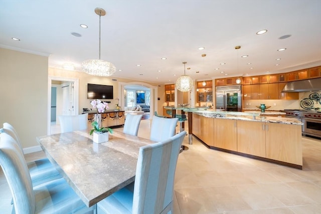 dining area featuring sink, an inviting chandelier, and crown molding