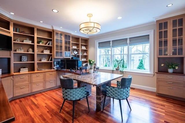 office with light wood-type flooring, crown molding, and built in shelves