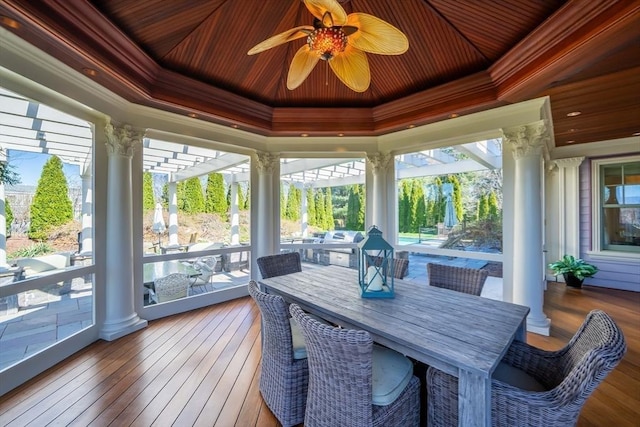 sunroom with ceiling fan, wood ceiling, a raised ceiling, and a wealth of natural light