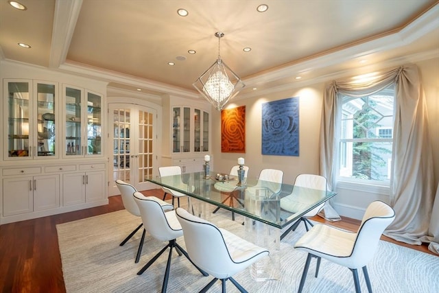 dining space featuring light hardwood / wood-style floors, ornamental molding, a chandelier, and a tray ceiling