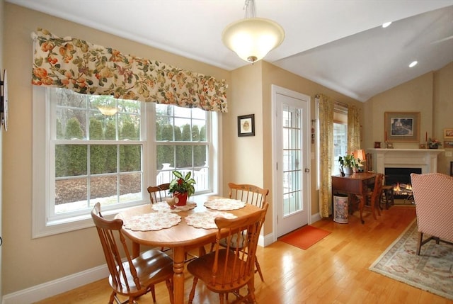 16 John Francis Ln Unit 16, Acton, MA 01720 - dining room featuring baseboards, a lit fireplace, and light wood-style floors