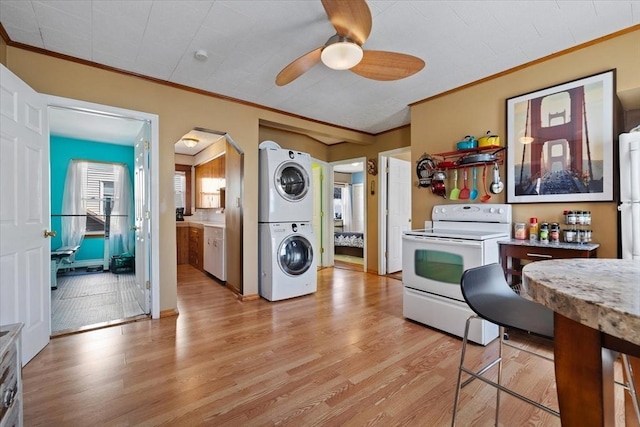 kitchen with white appliances, stacked washer and dryer, ceiling fan, crown molding, and light wood-type flooring