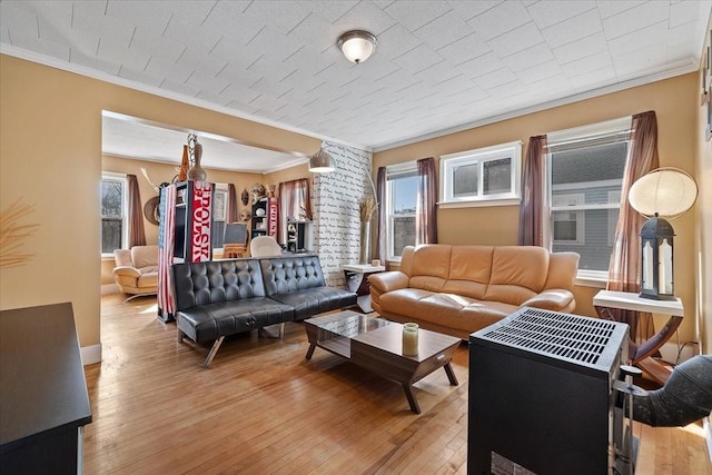 living room with baseboards, light wood-style flooring, and crown molding