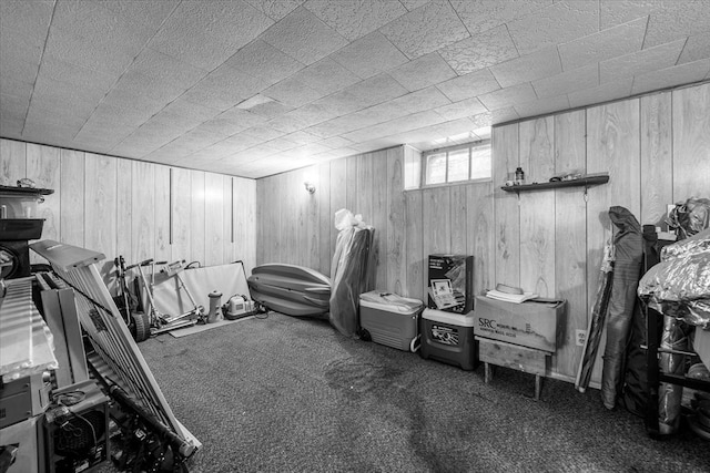 exercise room with carpet floors and wood walls