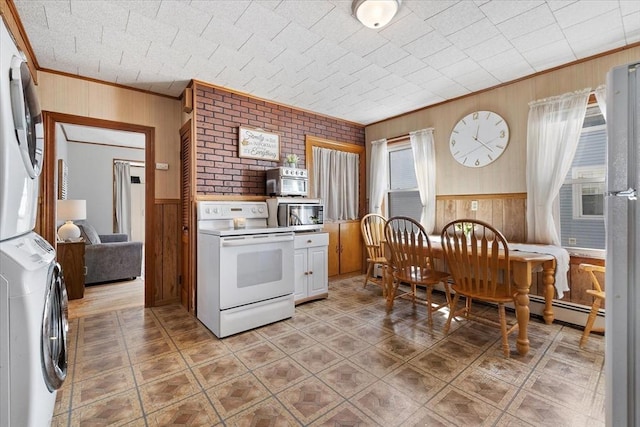 kitchen featuring ornamental molding, stacked washer and clothes dryer, stainless steel microwave, and white range with electric cooktop