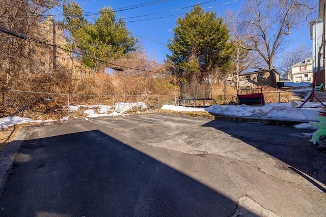 view of yard featuring a trampoline and fence