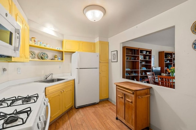 kitchen featuring light wood-style flooring, a sink, open shelves, white appliances, and light countertops