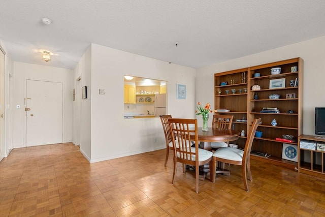 dining area featuring baseboards and a textured ceiling