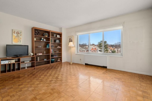 interior space featuring radiator, a textured ceiling, and baseboards