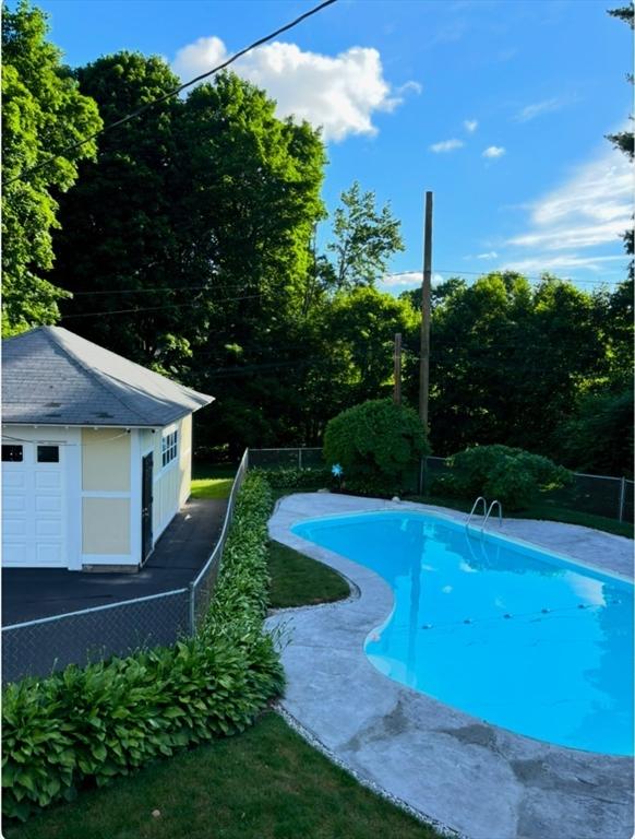 pool featuring an outdoor structure and fence