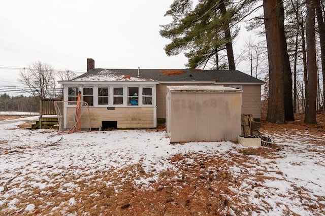 snow covered house with a sunroom