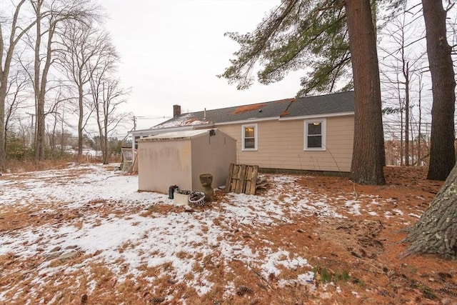 view of snow covered back of property