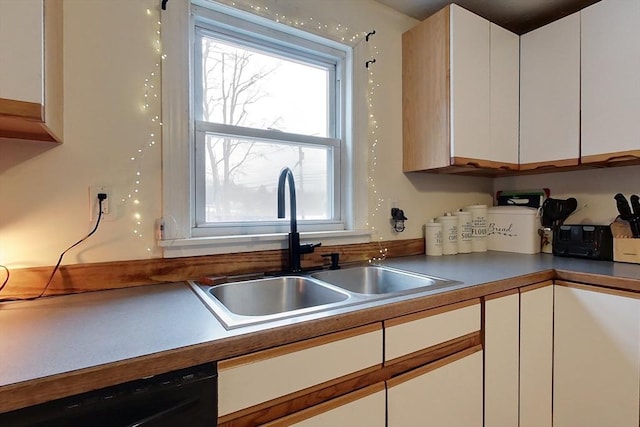 kitchen featuring white cabinetry, sink, and black dishwasher