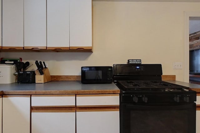 kitchen with white cabinetry and black appliances