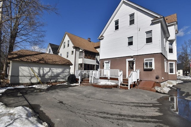 back of property with a deck and stucco siding