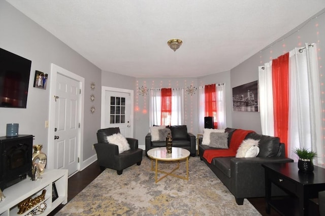 living area with dark wood-style flooring and baseboards