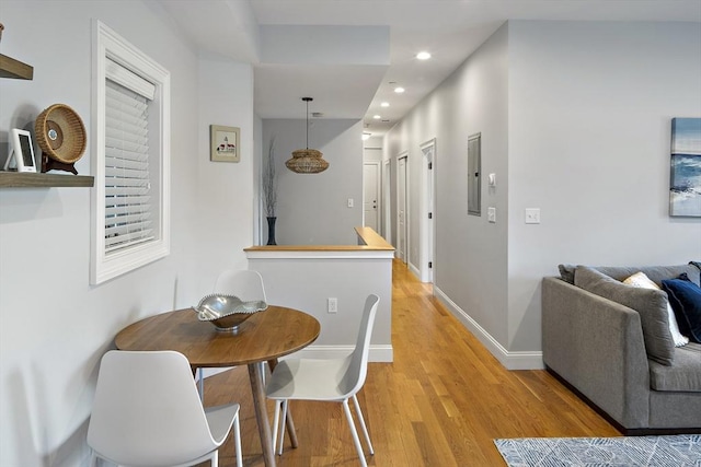 dining area featuring baseboards, light wood finished floors, and recessed lighting