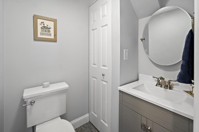 bathroom featuring baseboards, vanity, and toilet