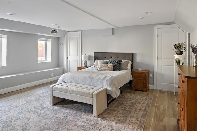 bedroom featuring light wood-type flooring, visible vents, and baseboards