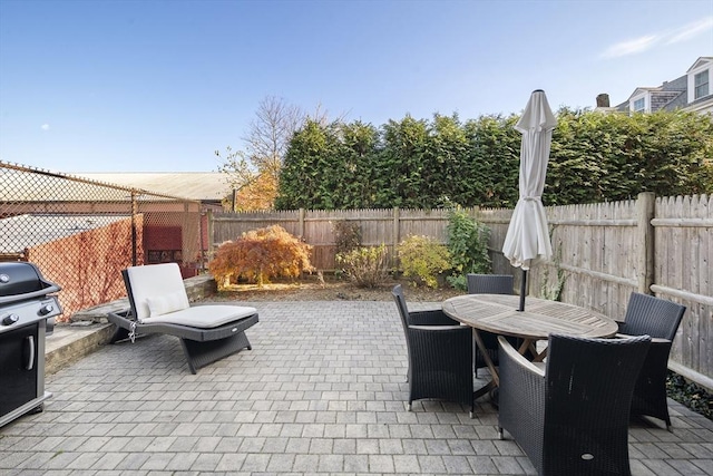 view of patio / terrace with a fenced backyard, grilling area, and outdoor dining space