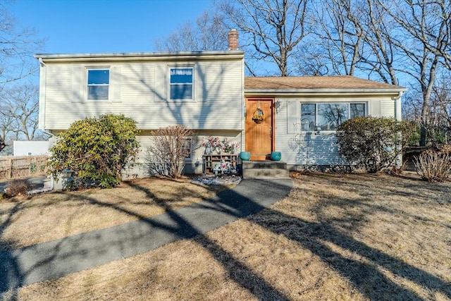 tri-level home featuring a chimney and entry steps