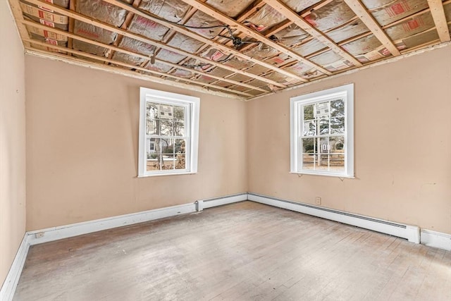 basement featuring wood-type flooring and baseboard heating