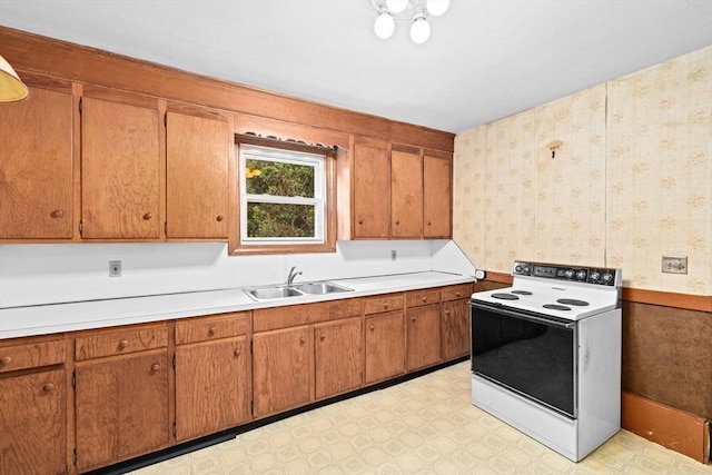 15 Rand St, Randolph, MA 02368 - kitchen with electric range oven, wallpapered walls, light countertops, brown cabinetry, and light floors