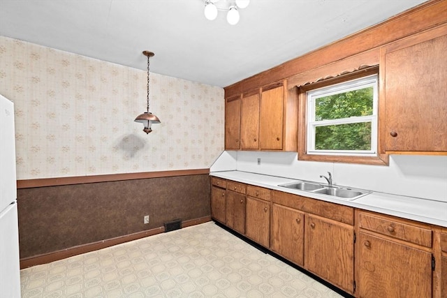 15 Rand St, Randolph, MA 02368 - kitchen with wainscoting, light countertops, brown cabinetry, pendant lighting, and light floors
