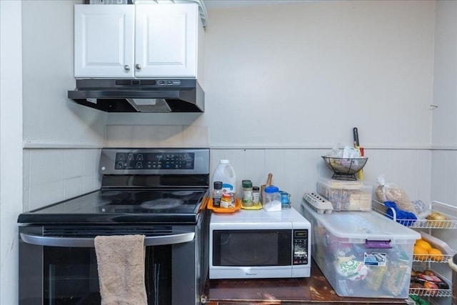 kitchen featuring decorative backsplash, white cabinetry, and stainless steel electric range