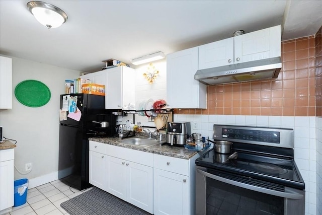 kitchen featuring black fridge, sink, electric stove, light tile patterned floors, and white cabinetry