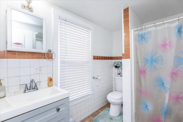 bathroom featuring a shower with curtain, vanity, toilet, and tile walls