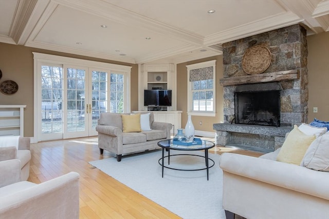 living room featuring hardwood / wood-style floors, crown molding, a fireplace, and beamed ceiling