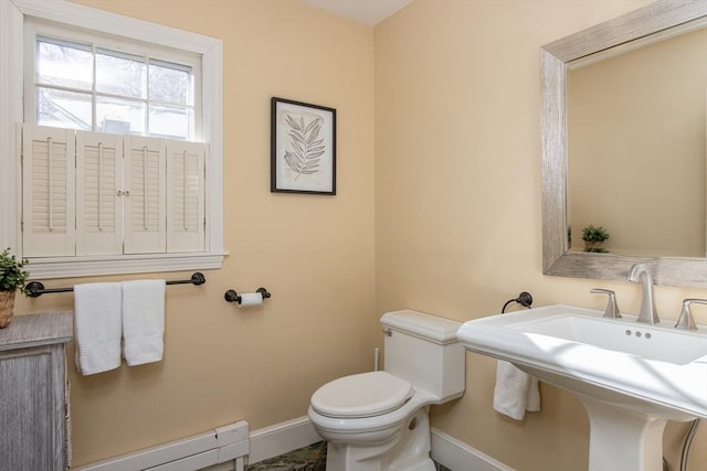 bathroom featuring a baseboard radiator, toilet, and sink