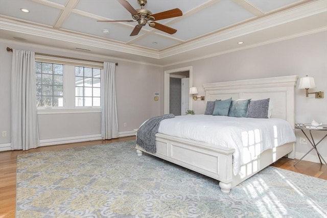 bedroom featuring hardwood / wood-style flooring, ceiling fan, ornamental molding, and coffered ceiling