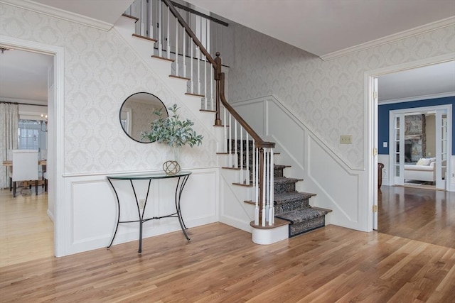 stairway featuring hardwood / wood-style floors and crown molding