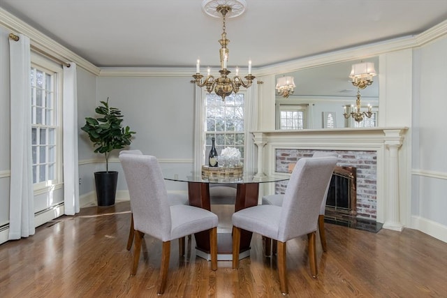 dining area with dark hardwood / wood-style floors, a brick fireplace, a wealth of natural light, and ornamental molding