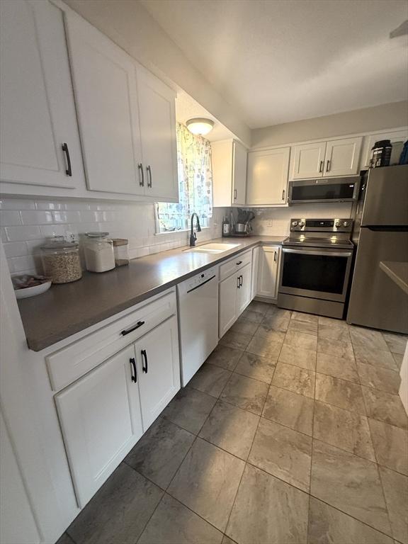 6 Gates St, Monson, MA 01057 - kitchen with appliances with stainless steel finishes, decorative backsplash, white cabinets, ventilation hood, and dark countertops