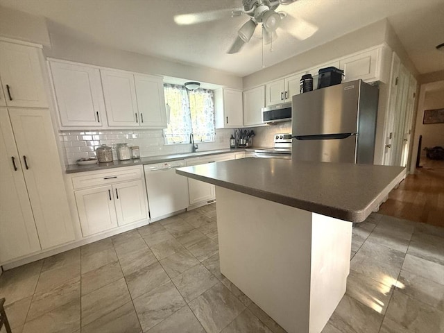 6 Gates St, Monson, MA 01057 - kitchen with appliances with stainless steel finishes, a ceiling fan, tasteful backsplash, white cabinets, and a center island