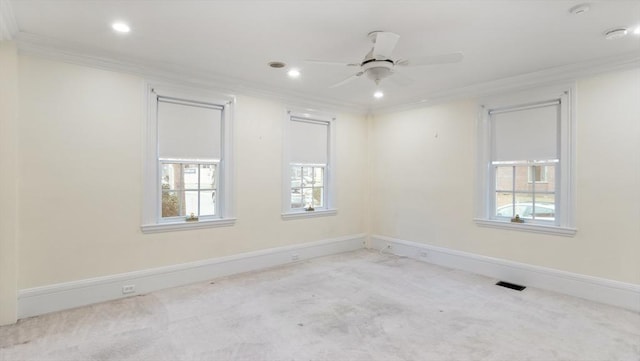 carpeted empty room featuring baseboards, a healthy amount of sunlight, a ceiling fan, and crown molding