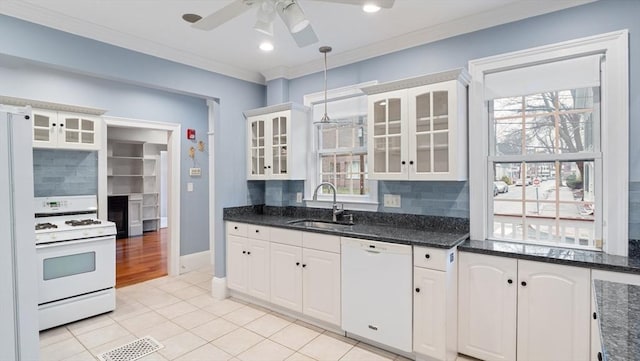 kitchen with white appliances, a sink, backsplash, glass insert cabinets, and crown molding