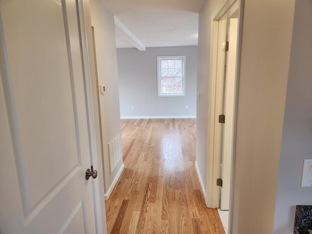 hallway featuring beam ceiling and light hardwood / wood-style floors