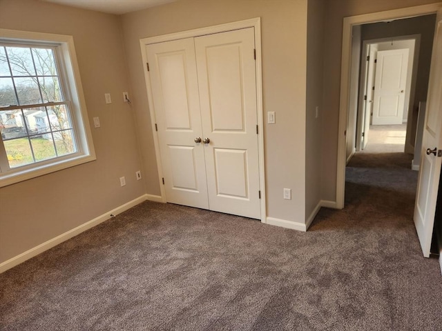 unfurnished bedroom featuring a closet and dark carpet