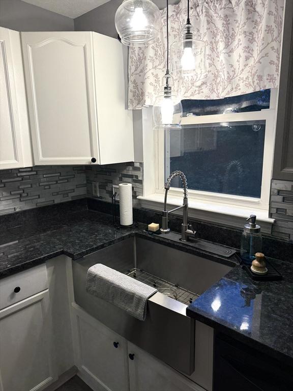104 Orton St Unit 104, Worcester, MA 01604 - kitchen featuring a sink, tasteful backsplash, white cabinetry, and dark stone countertops