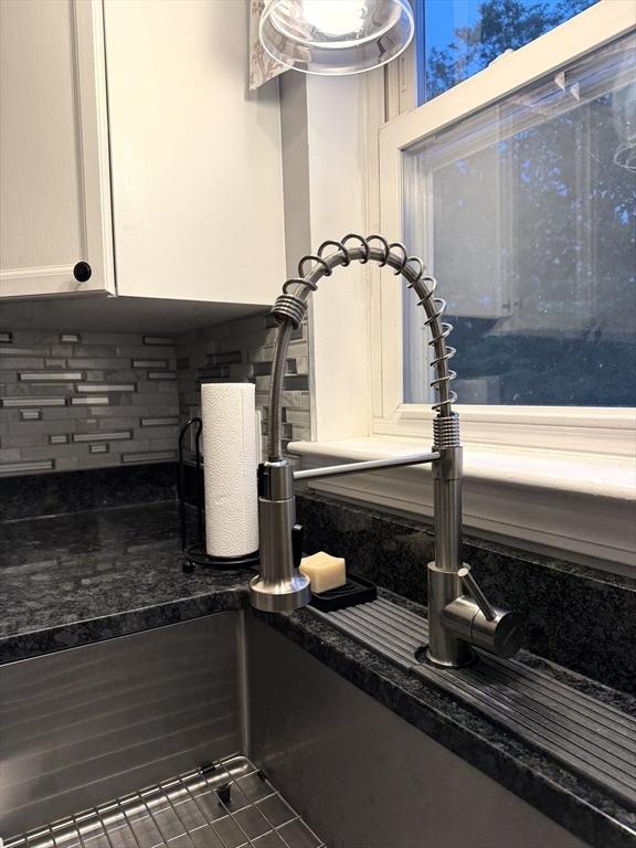 104 Orton St Unit 104, Worcester, MA 01604 - kitchen view of a sink, backsplash, and white cabinetry