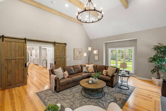 living room featuring high vaulted ceiling, light wood-type flooring, beam ceiling, and a barn door