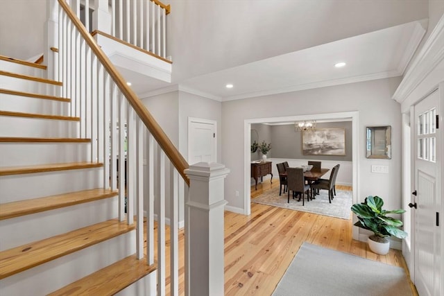 foyer featuring light wood-type flooring, crown molding, and recessed lighting